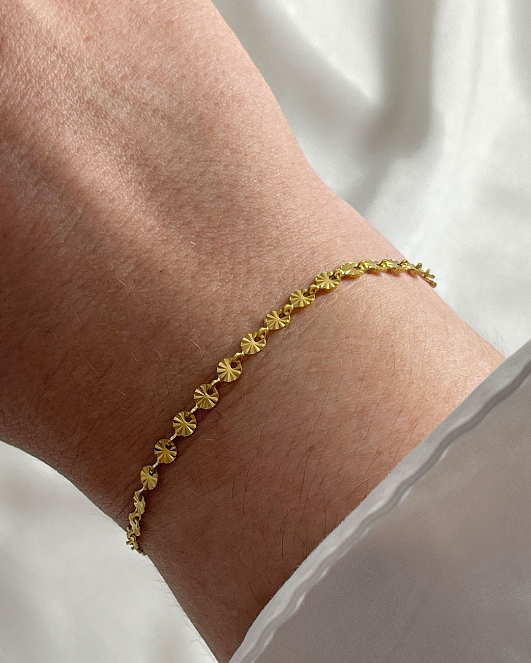 Wrist with sun chain bracelet in gold finish