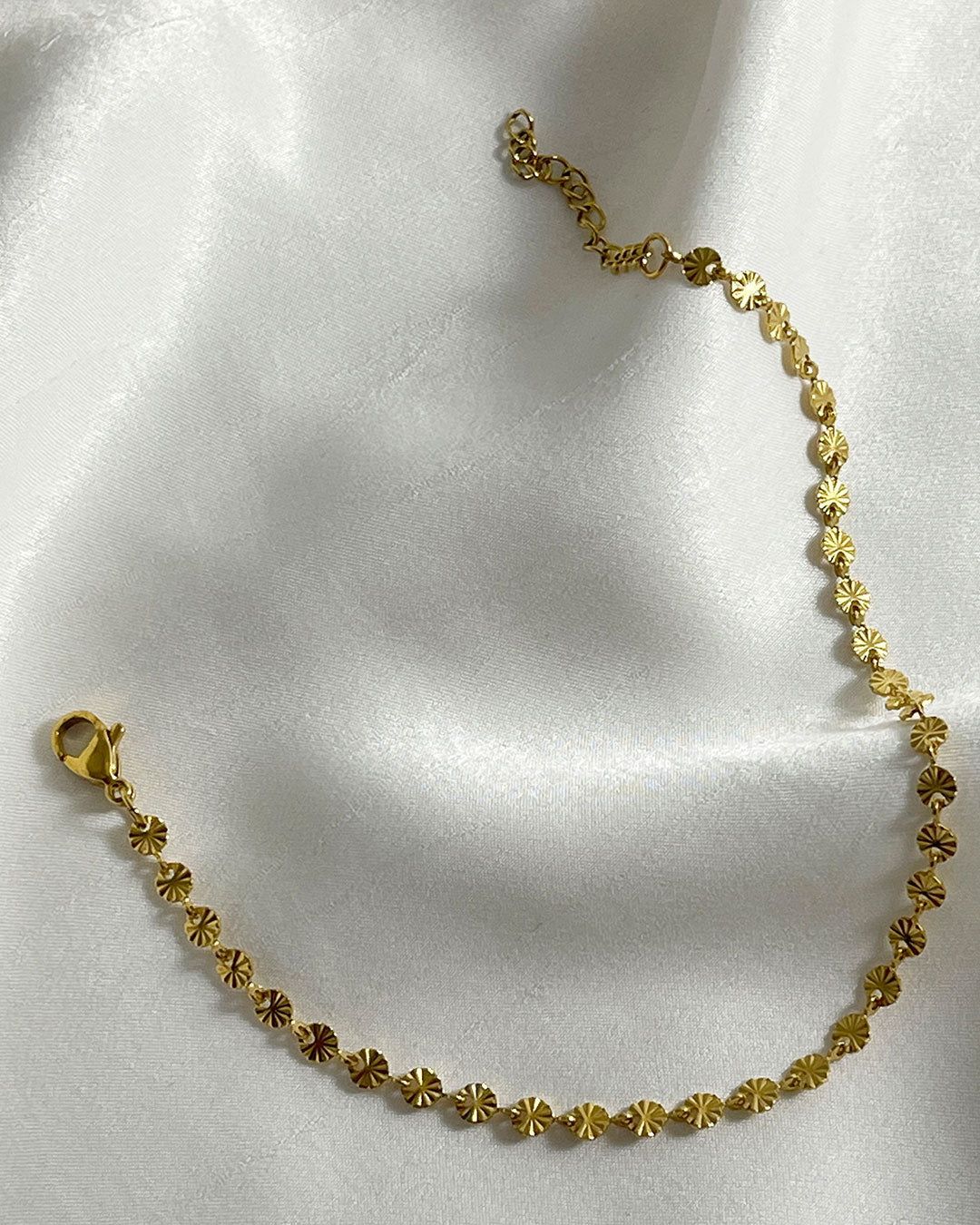 Close-up look of a gold sun chain bracelet