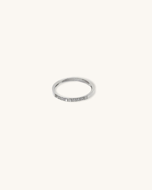 A waterproof silver band ring with diamonds on neutral brackground
