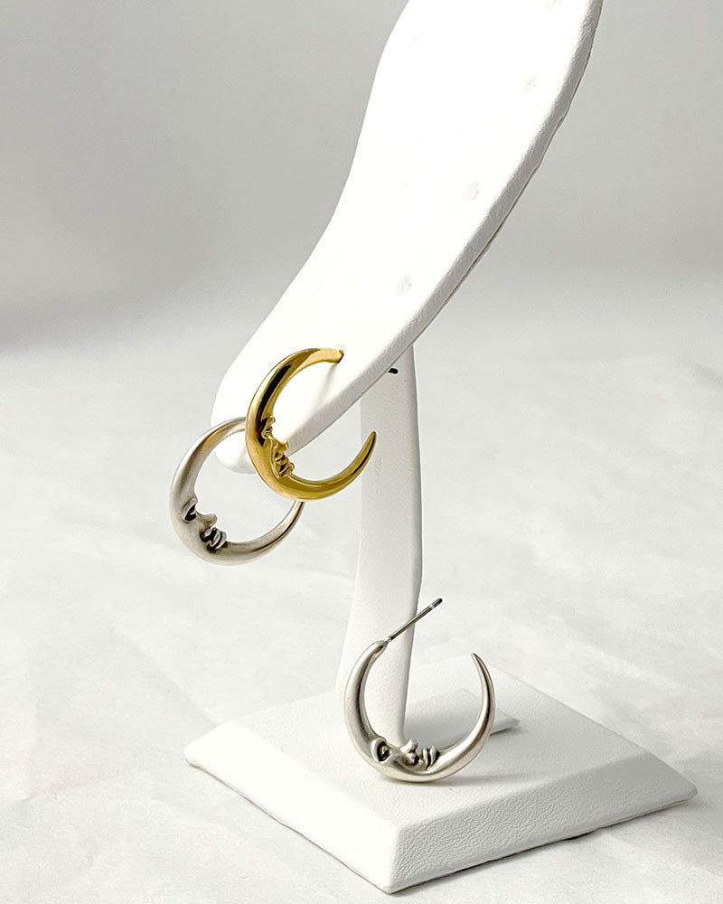 The Crescent Moon Earrings, a pair of half-moon-shaped gold earrings