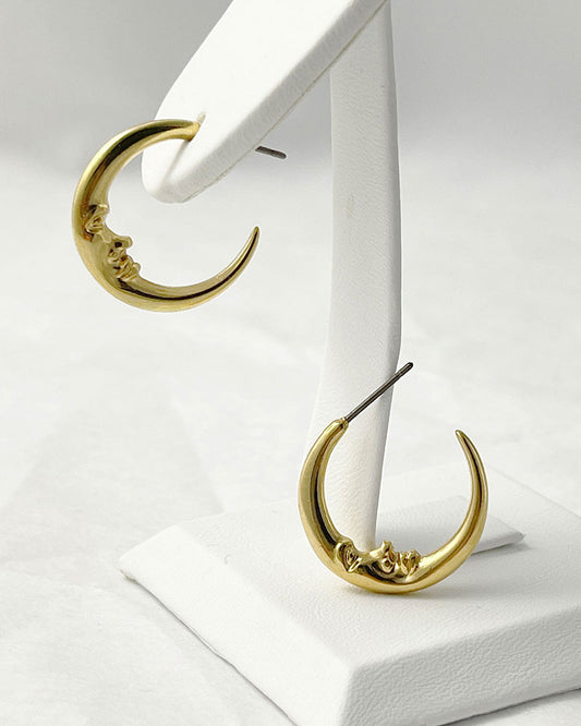 The Crescent Moon Earrings, a pair of half-moon-shaped gold earrings