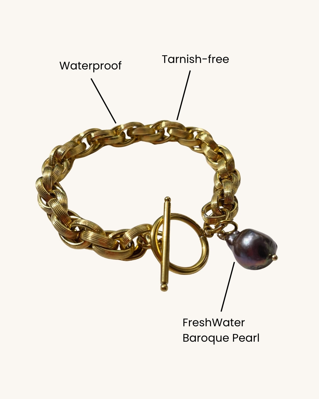 Gold toggle bracelet featuring a braided chain design and a dark gray baroque pearl accent. The bracelet has a substantial, chunky link style and a secure clasp. The pearl is a focal point, adding a touch of elegance to the bold gold chain. This statement piece is perfect for adding a touch of luxury to any outfit.