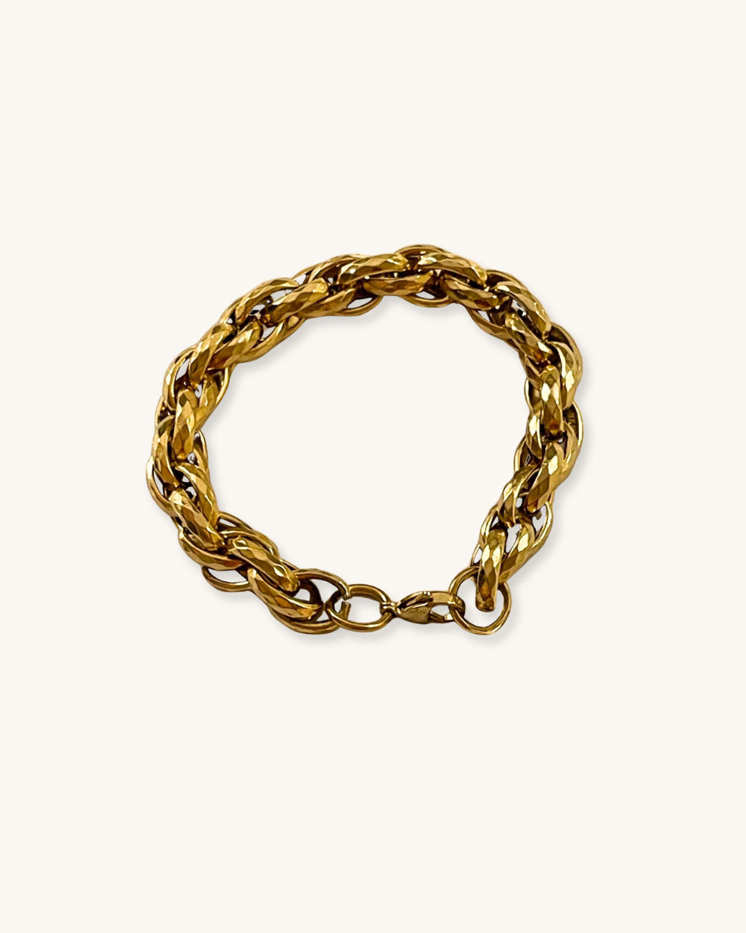 Gold chunky braided chain bracelet on a white background