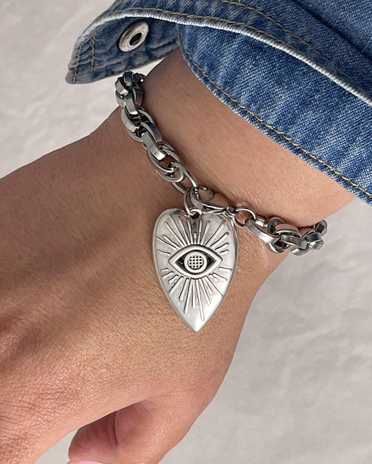 Our gorgeous silver chunky chain evil eye heart charm bracelet enhances a woman's wrist with its exquisite design and timeless allure.