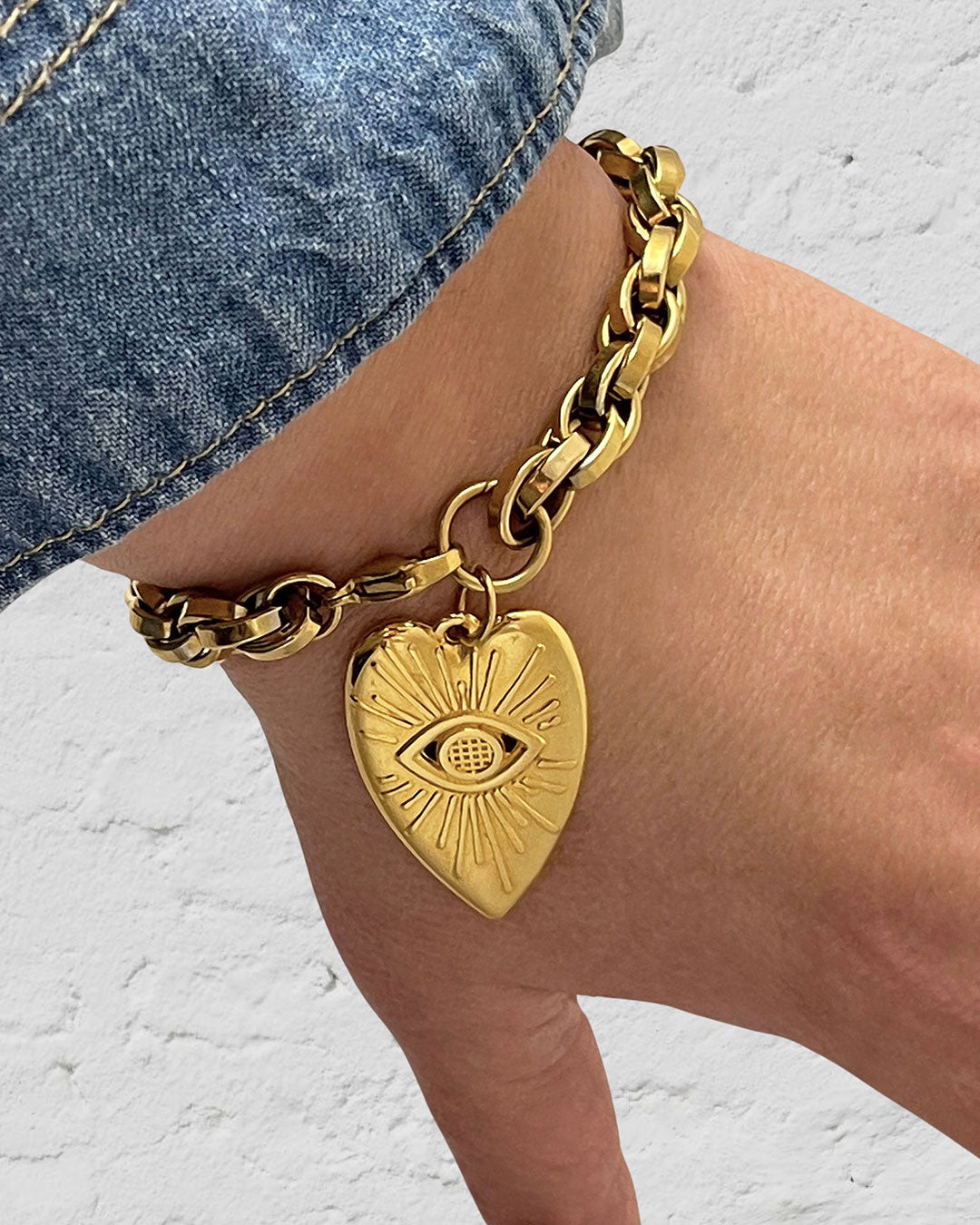 Our gorgeous gold chunky chain evil eye heart charm bracelet enhances a woman's wrist with its exquisite design and timeless allure.