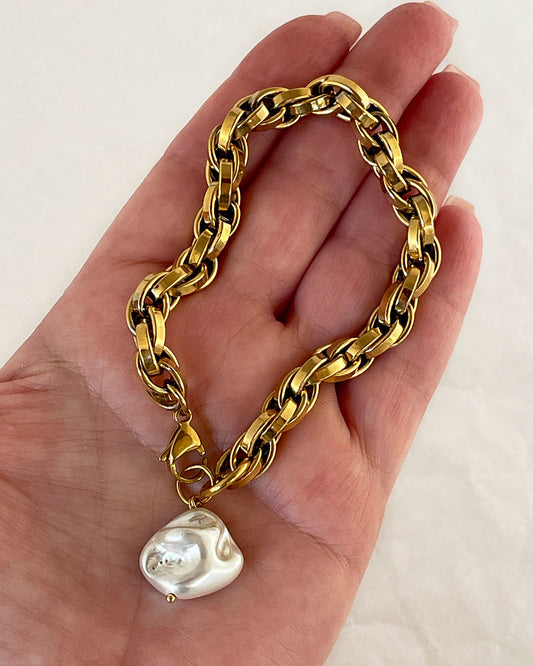 A chunky chain bracelet with shell pearl charm