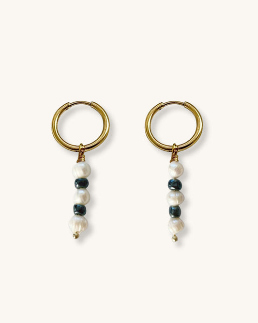 The Lady Hoop Earrings, a pair of gold hoop earrings featuring freshwater pearls and black glass beads.