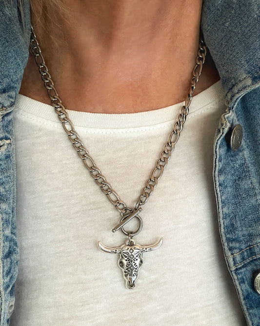 Model wearing a silver necklace with a bull head pendant