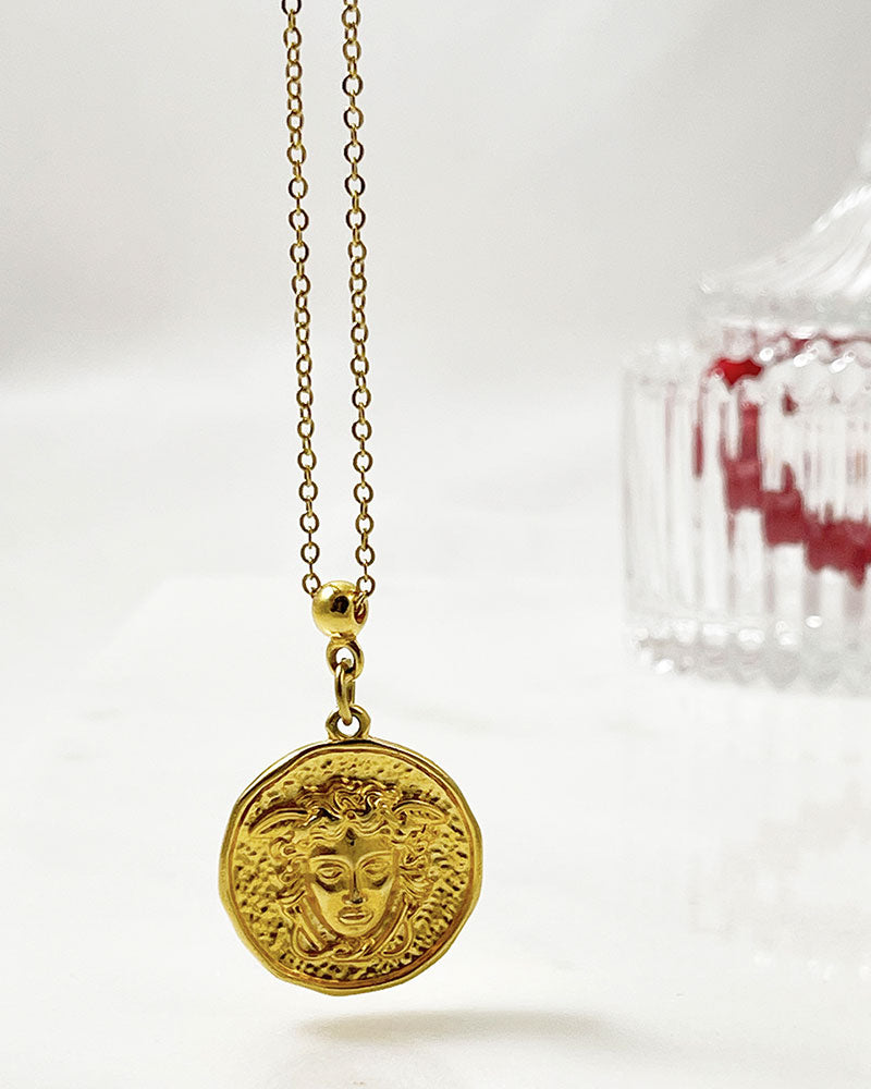 A beautifull gold round medusa head pendant necklace with a stainless steel chain.