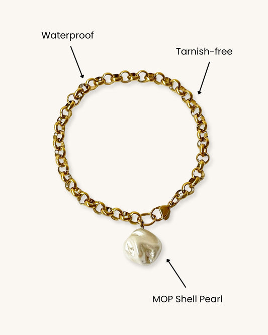 Gold rolo chain bracelet with MOP shell pearl on a white background