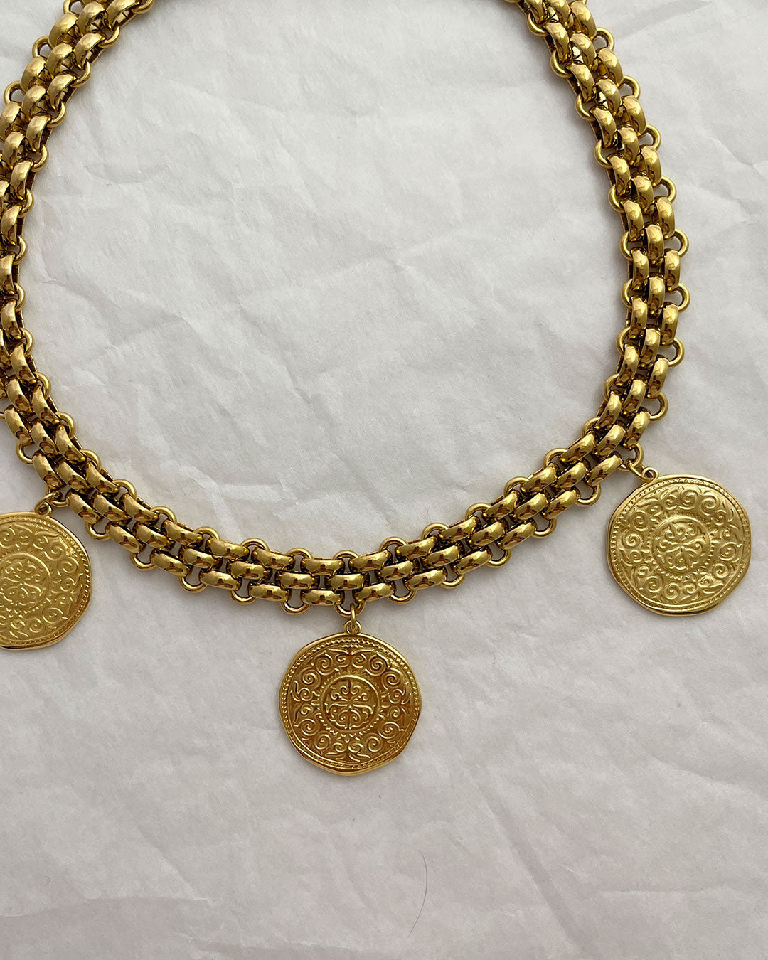 A multi coin choker necklace with a chunky chainmail chain in gold