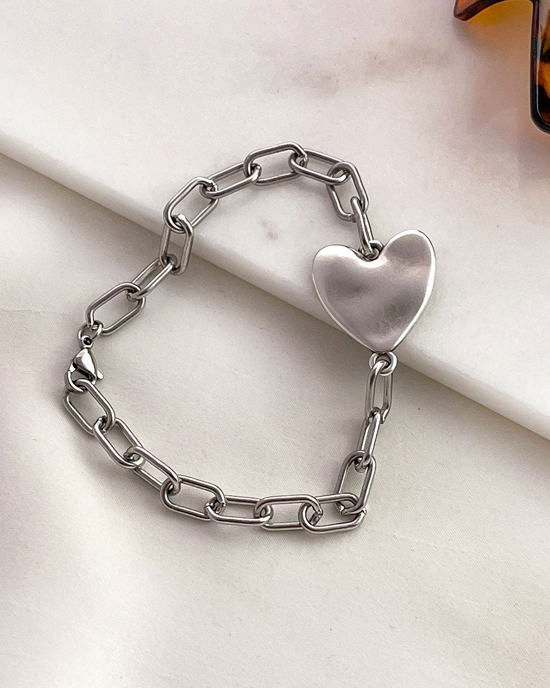 Silver heart bracelet on a marble surface