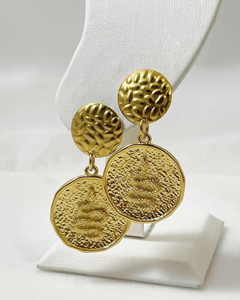 The Snake Earrings, a pair of gold earrings featuring a round snake charm.