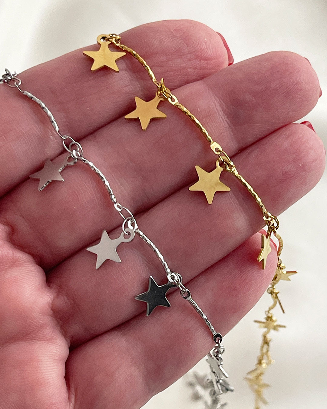 Closer details from two choker necklaces full of star charms in gold and silver
