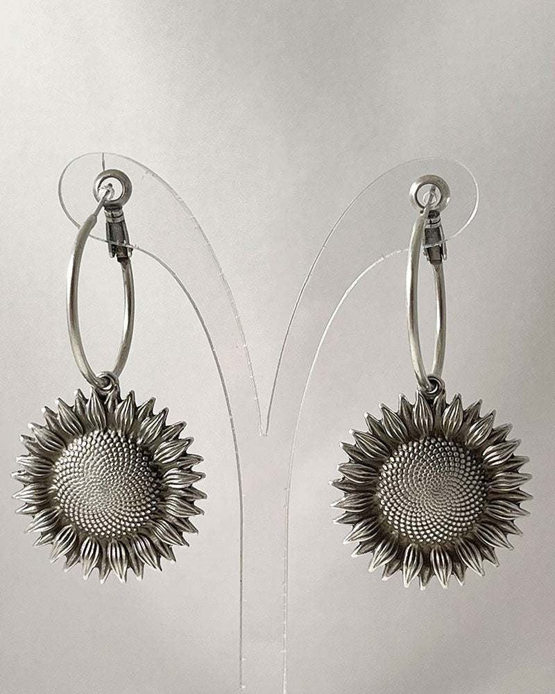 The Sunflower Hoop Earrings, a pair of silver hoop earrings featuring a sunflower charm.