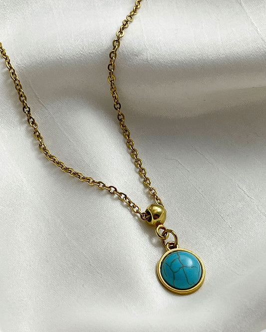 A turquoise pendant necklace in gold