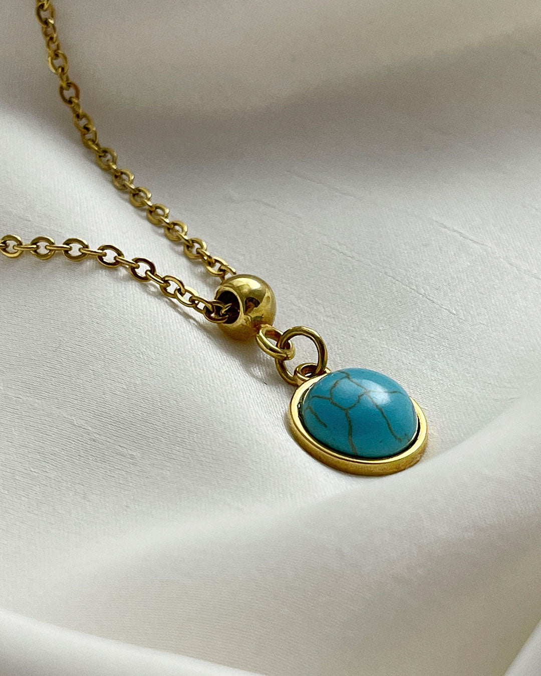 A turquoise pendant necklace in gold