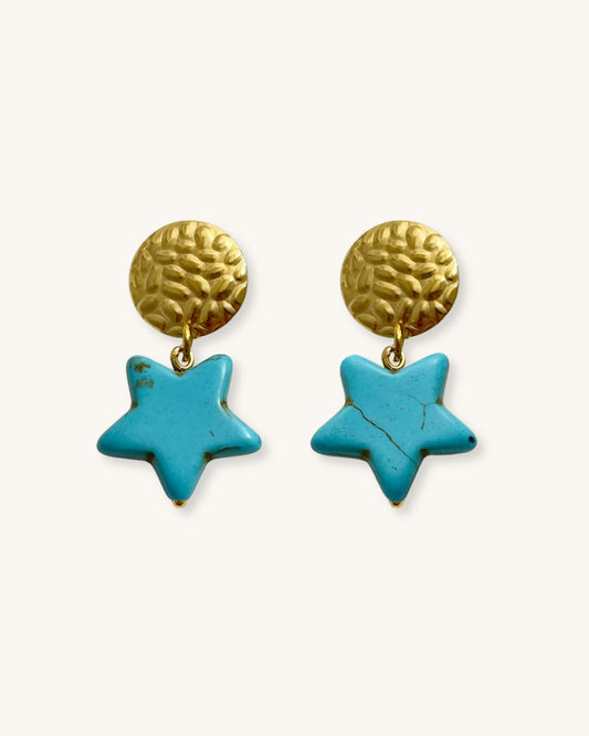 Pair of drop earrings with turquoise star charms and gold circular studs on a white background.
