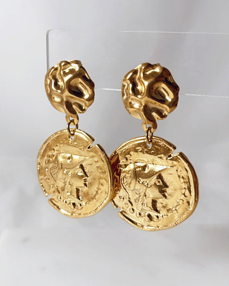 The Athena Coin Earrings, a pair of gold earrings featuring a raised design of Athena's goddess face accents on a coin.