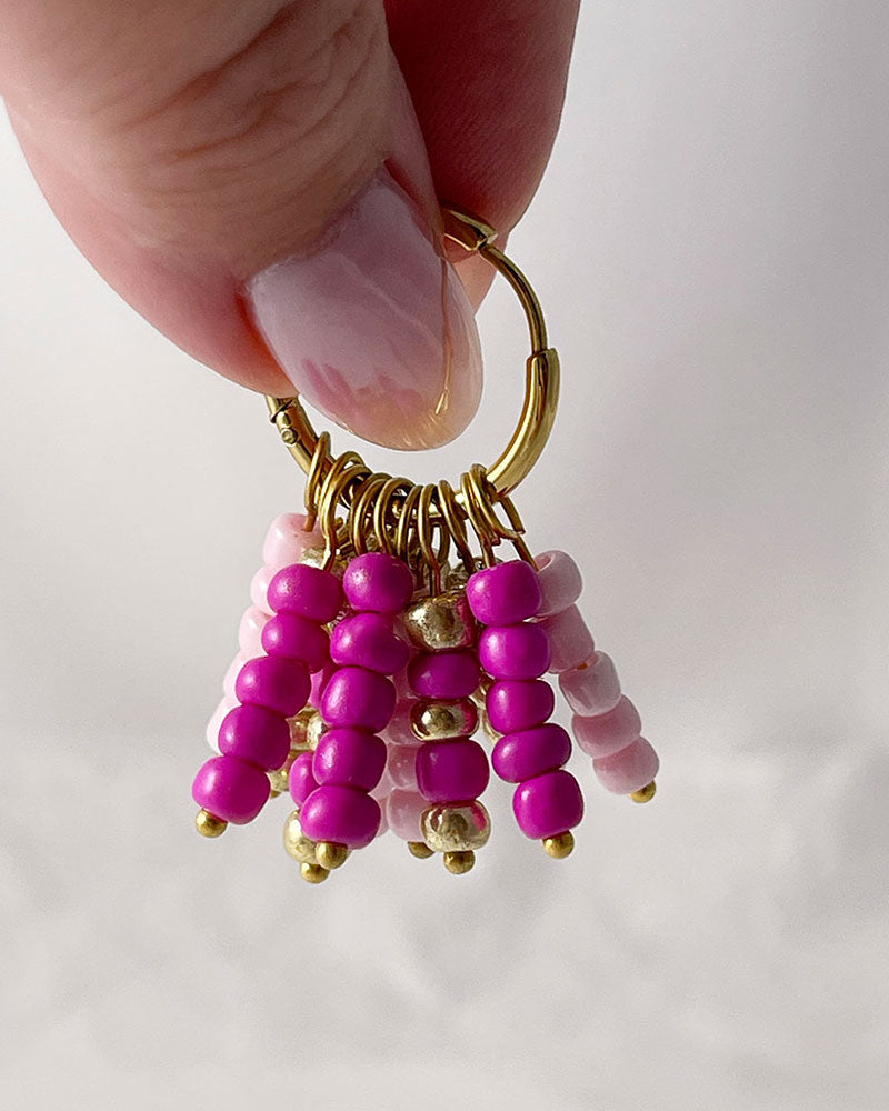 Boho beaded hoop earrings in pink, fuchsia, and gold colors with stainless steel hoops finished in 18K gold