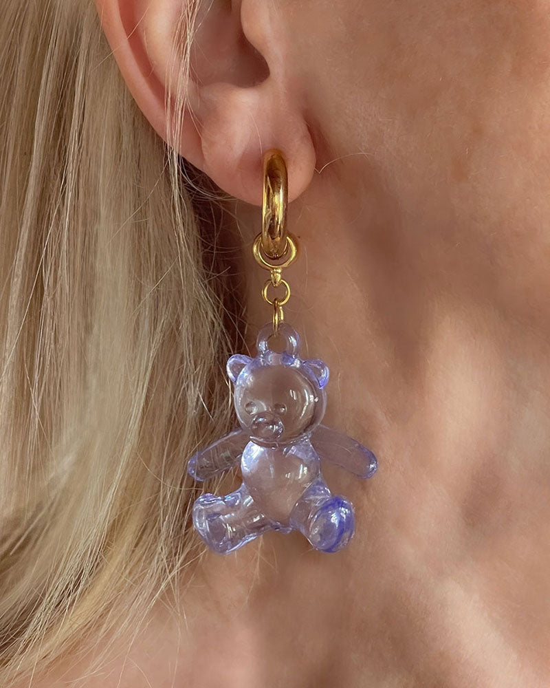 Model wearing gold chunky hoop earrings with large acrylic gummy bear