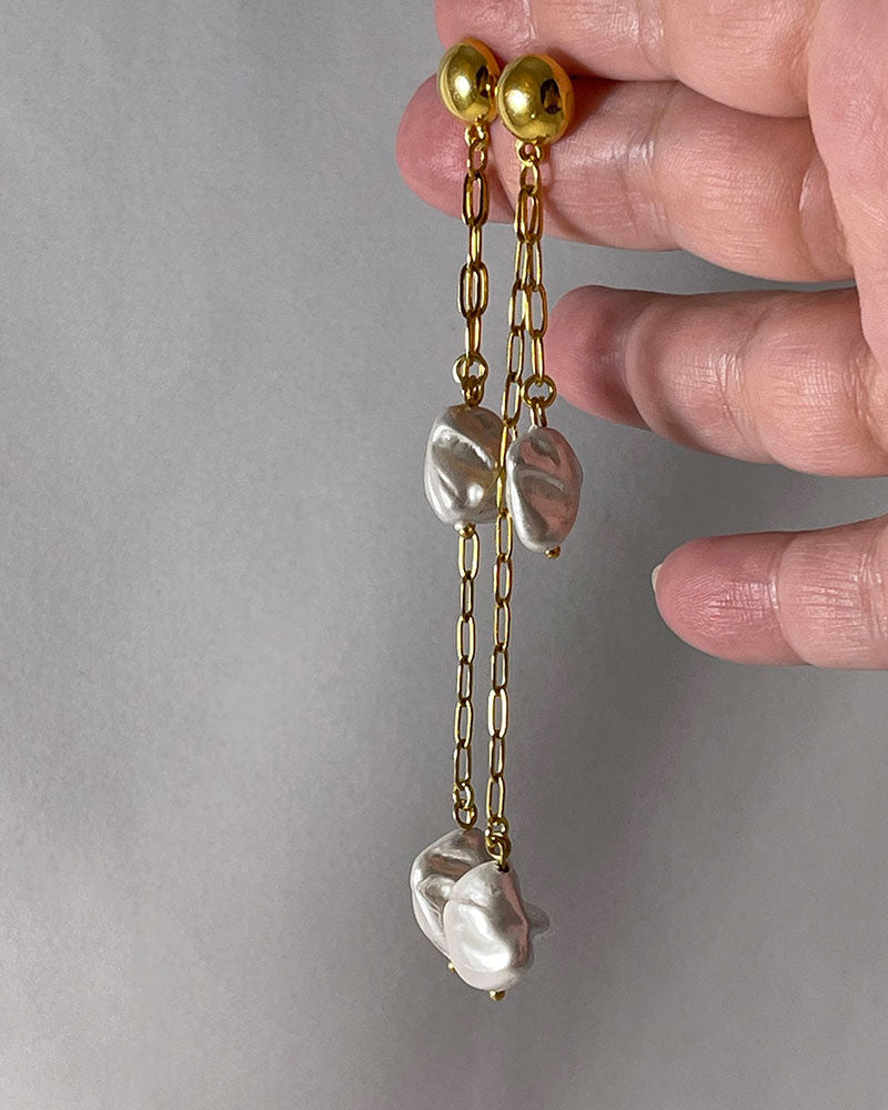 The Long Drop Pearl Shell Earrings, a pair of stud earrings featuring two paperclip chains with shell pearl pendants.