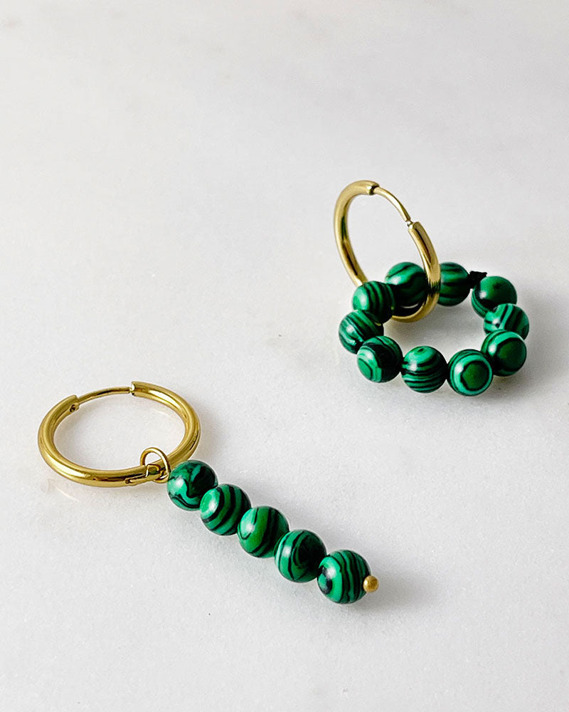 The Malachite Hoop Earrings, a pair of gold hoop earrings featuring malachite stones.