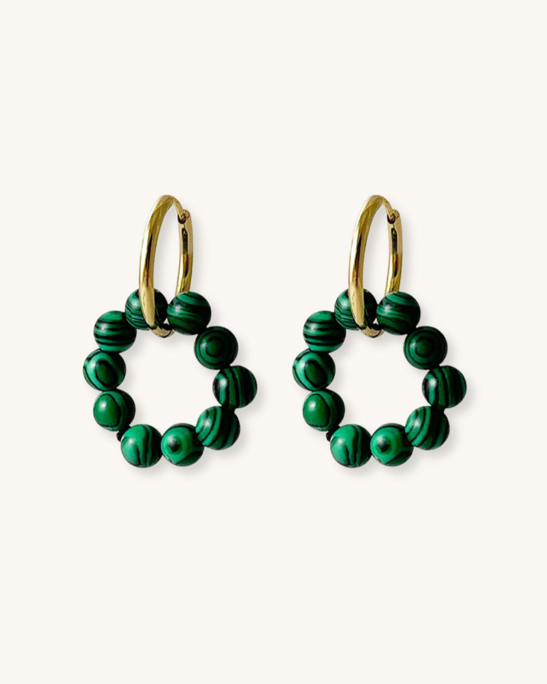 Pair of gold hoop earrings with rounded style malachite beads on a white background