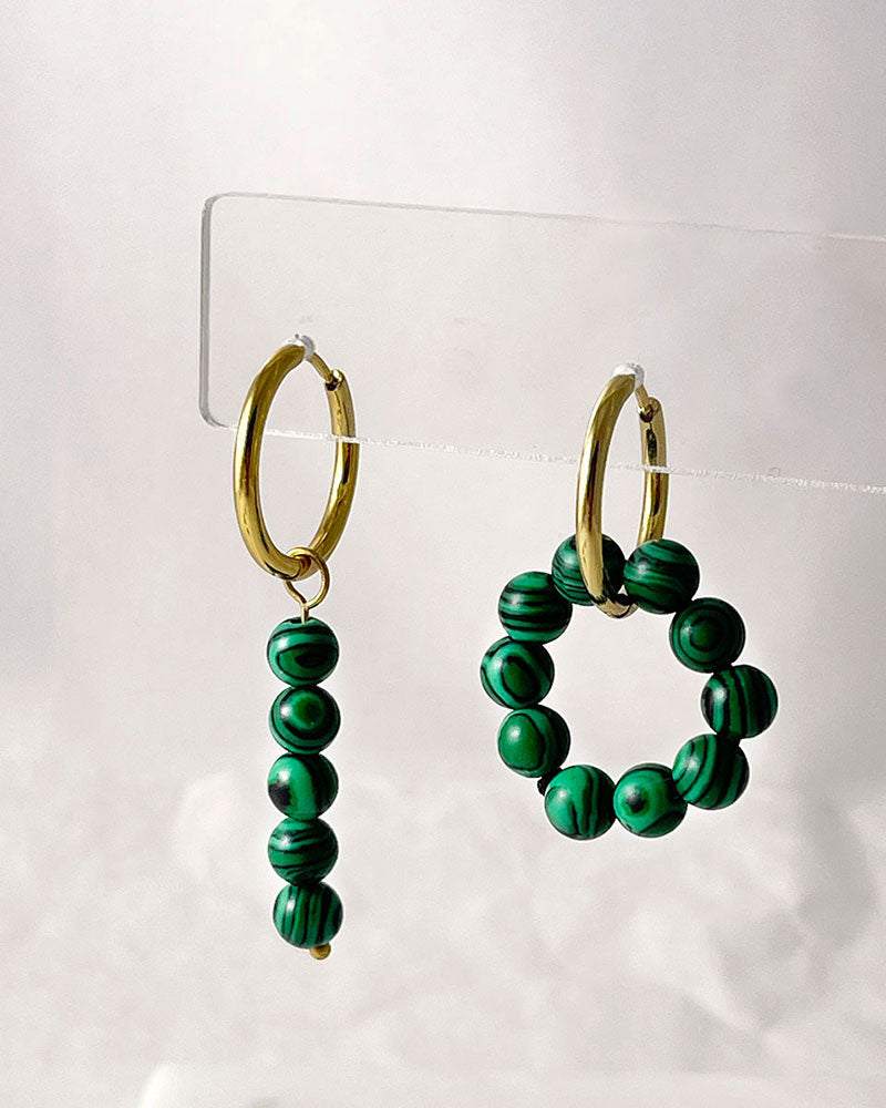 The Malachite Hoop Earrings, a pair of gold hoop earrings featuring malachite stones.