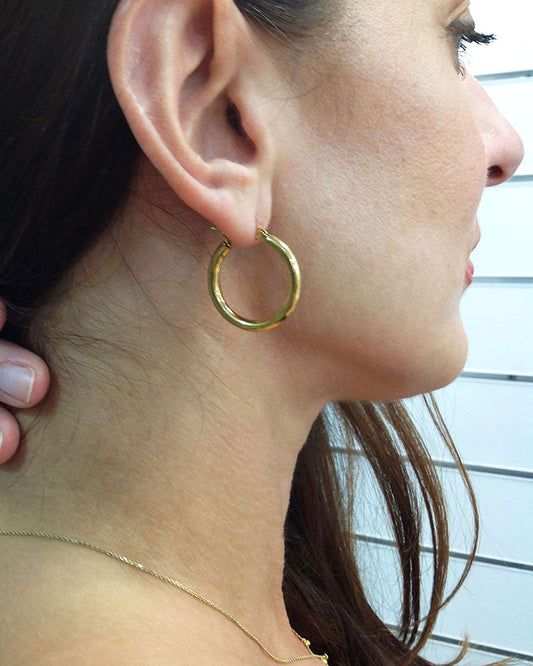 Model wearing the 25mm Gold Hoop Earrings, a pair of stainless steel hoops in gold
