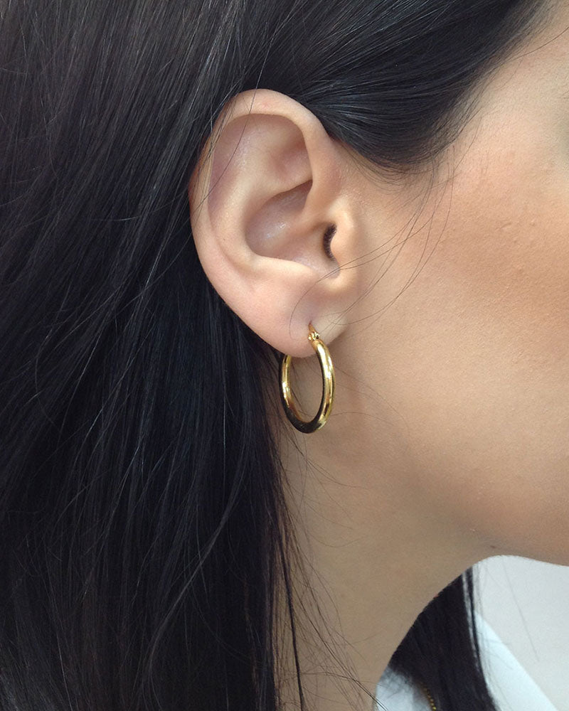 Model wearing the 25mm Gold Hoop Earrings, a pair of stainless steel hoops in gold