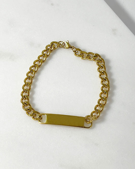 A chunky curb chain bracelet in gold connected by a solid bar at the center.