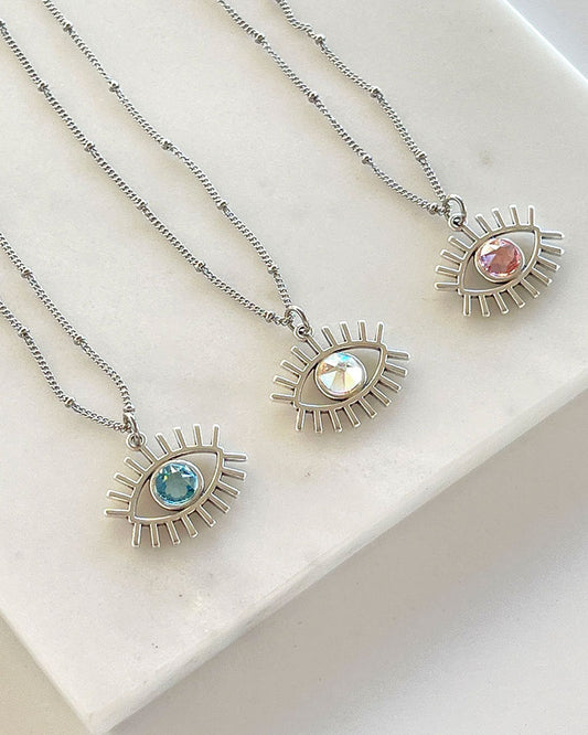 A dainty chain necklace with an evil eye pendant and a Swarovski crystal