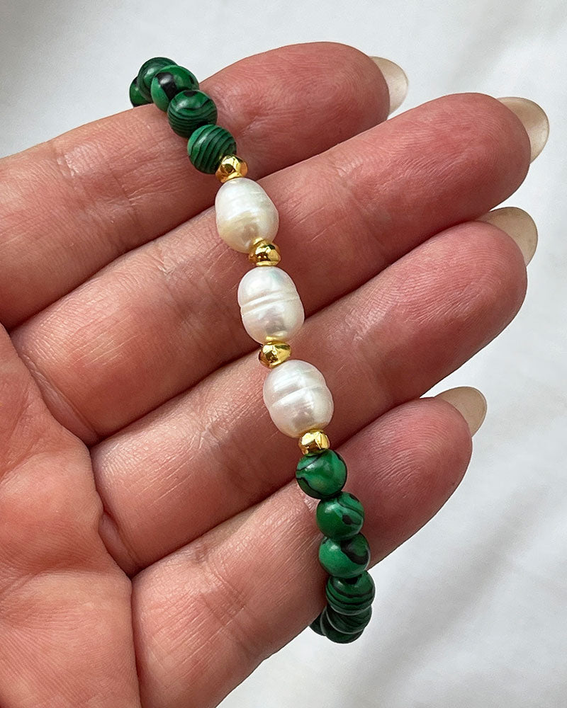 A handmade green malachite beaded bracelet with freshwater pearls. The bracelet has a gold stainless steel lobster clasp