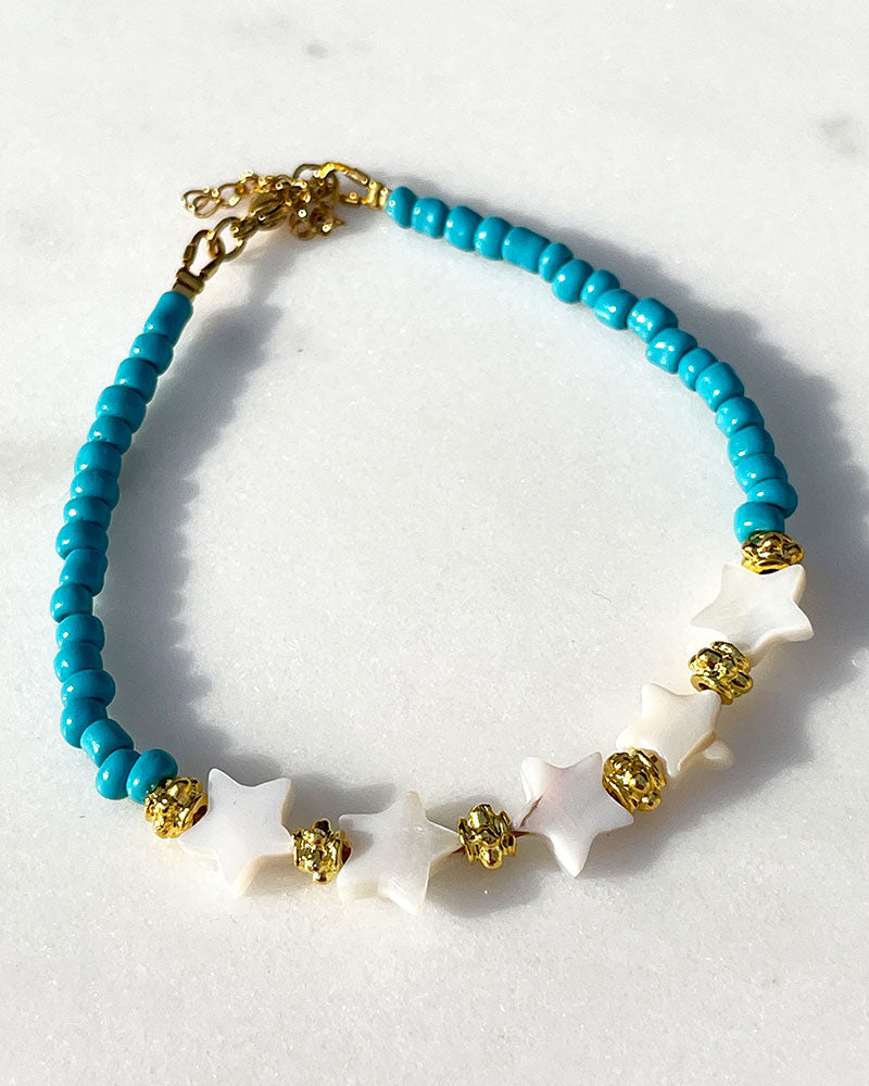 A Blue Boho Stars Beaded Anklet adorned with blue beads abd shell stars