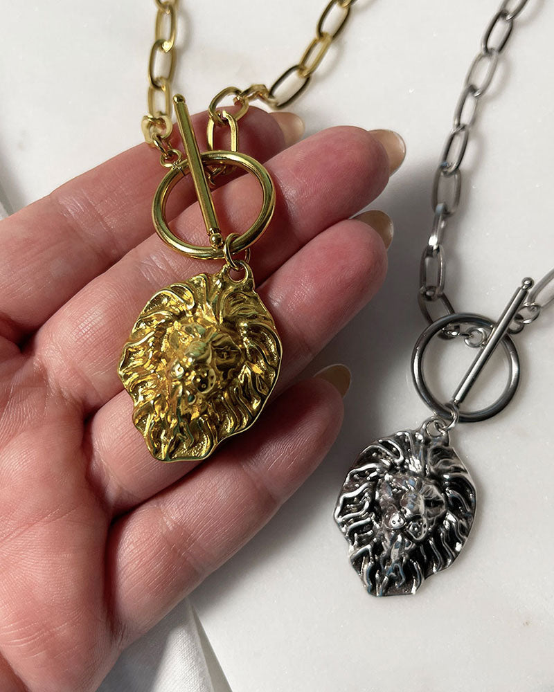 A gorgeous Leo head pendant is hanging from a trendy paperclip chain in gold and silver