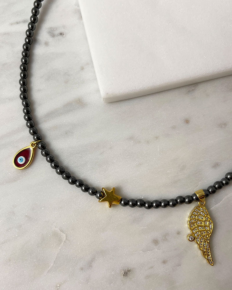 hematite beaded necklace with angle wing , star and eye charms