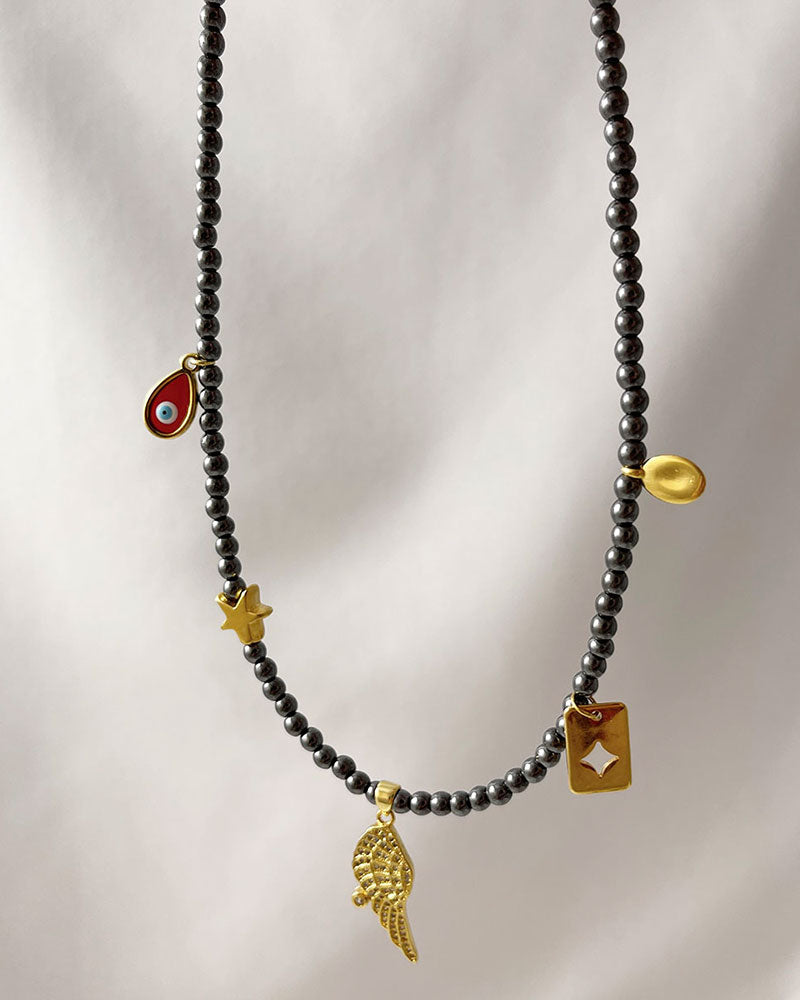 hematite beaded necklace with angle wing , star and eye charms