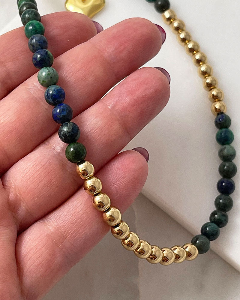 A handmade minimalist necklace with azurite and gold hematite beads