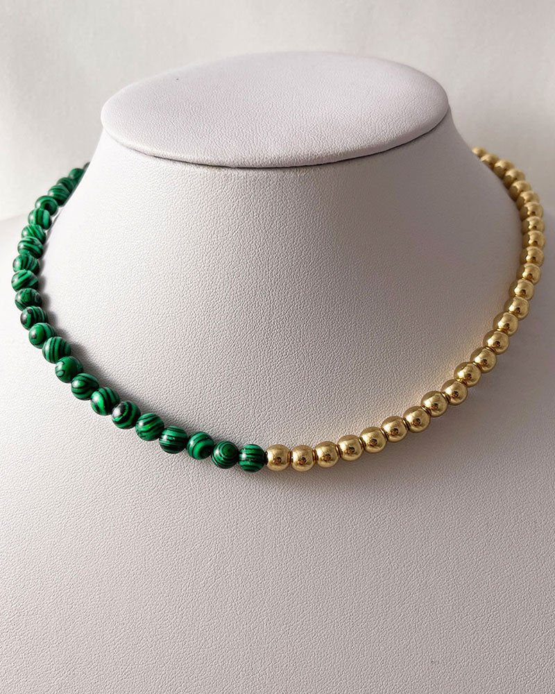 A handmade minimalist necklace with green malachite and gold hematite beads