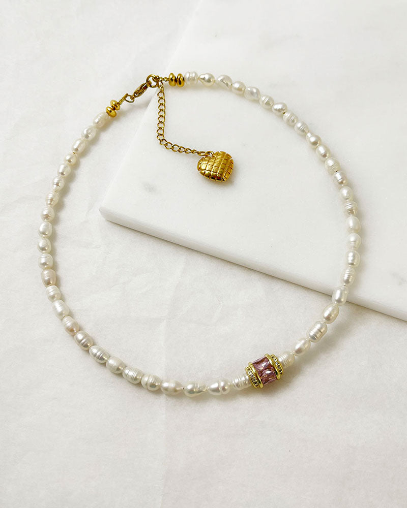 pearl choker necklace with a pink crystal bead in the middle