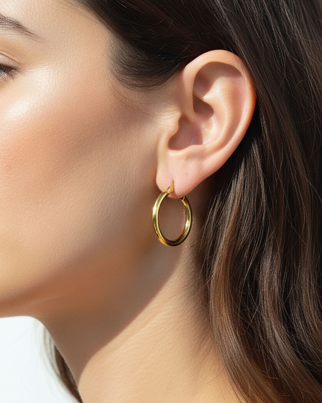 Model wearing the 25mm Gold Hoop Earrings, a pair of stainless steel hoops in gold