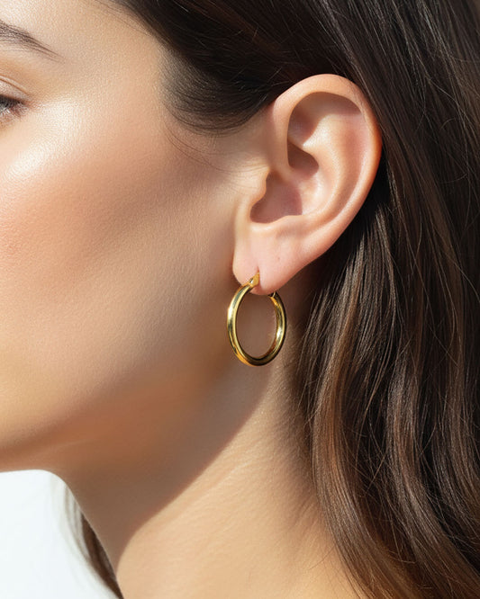 Model wearing the 25mm Gold Hoop Earrings, a pair of stainless steel hoops in gold
