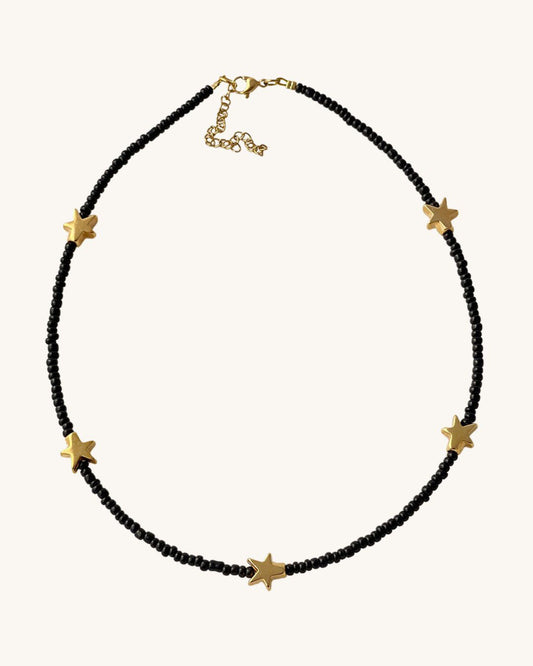 A black glass beaded necklace with five gold metal stars.