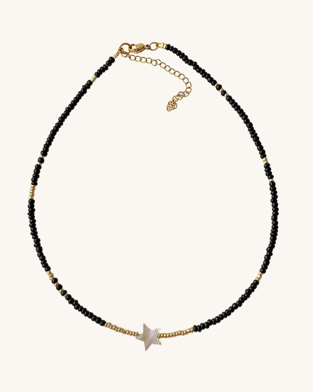 A black gold beaded necklace with an ivory star