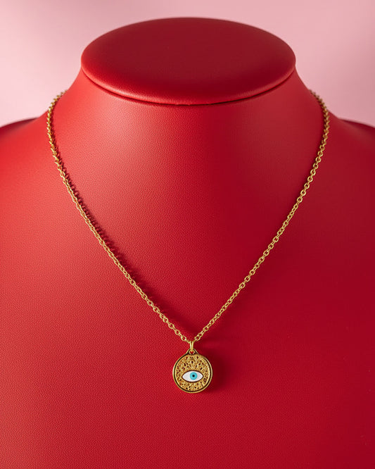 Gold evil eye pendant necklace on a red mannequin