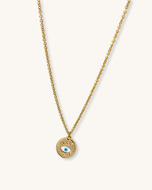 A dainty chain necklace with a small round pendant. The pendant is gold with a white blue enamel evil eye design.