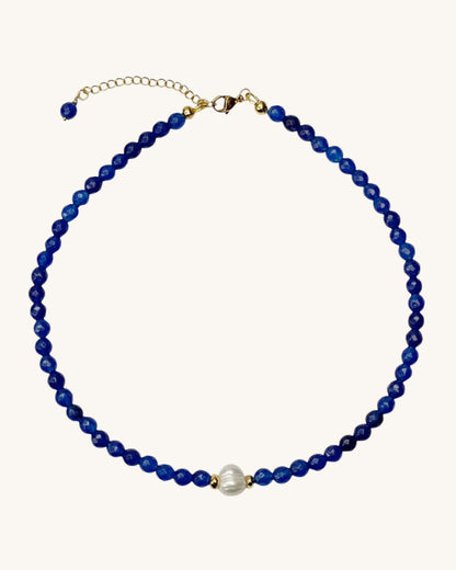 A blue agate gemstone beaded necklace with a single white pearl.