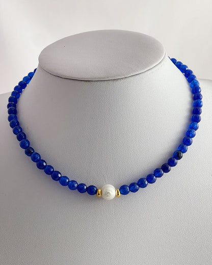 A blue agate gemstone beaded necklace with a single white pearl.