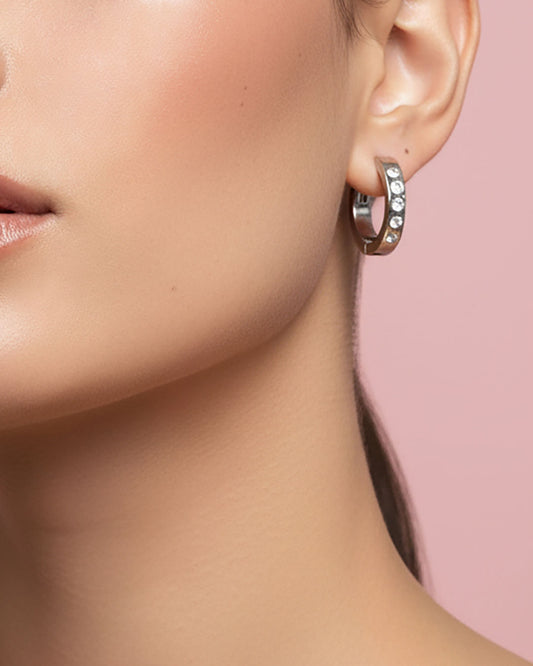 Model wearing waterproof silver hoop earrings adorned with crystal cubic zirconia